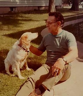 man petting yellow Labrador retriever sitting next to him