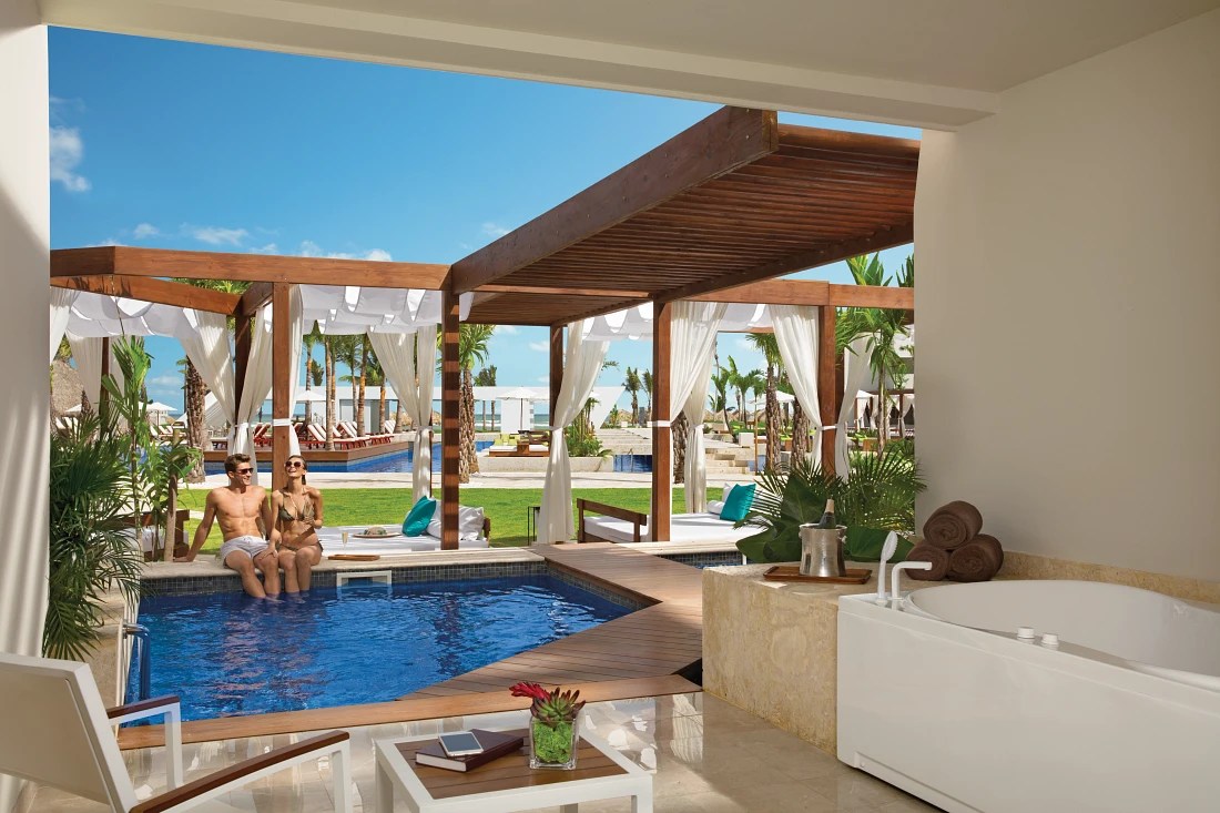 Man and woman sitting on the edge of a private hotel suite pool