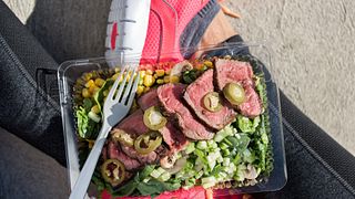 Meal prep fitness lifestyle - Woman taking food selfie top view photo of her prepared ready to go lunch box for healthy paleo diet - Steak salad take-out eating girl at gym.