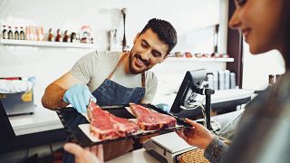 Consumer Choosing Steak at Retail Counter