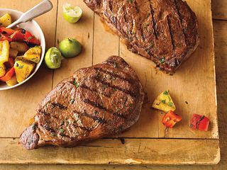 Ribeye steaks are spiced up with cilantro, cumin and ground red pepper and served with a simple salad of pineapple, red pepper and lime.