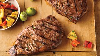 Ribeye steaks are spiced up with cilantro, cumin and ground red pepper and served with a simple salad of pineapple, red pepper and lime.