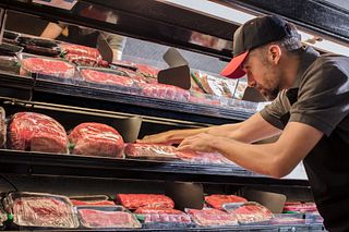 Butcher stocking meat case Butcher stocking meat case