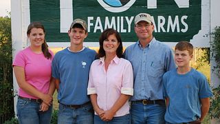 Family members standing in front of a sign at Yon Family Farm
