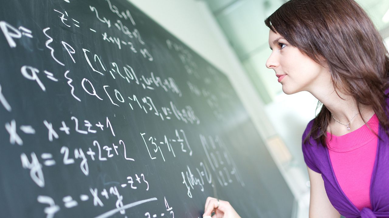 student writing on the chalkboard/blackboard