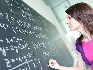 Student Writing on Chalkboard