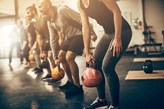 Fit people lifting dumbbells together during a workout session