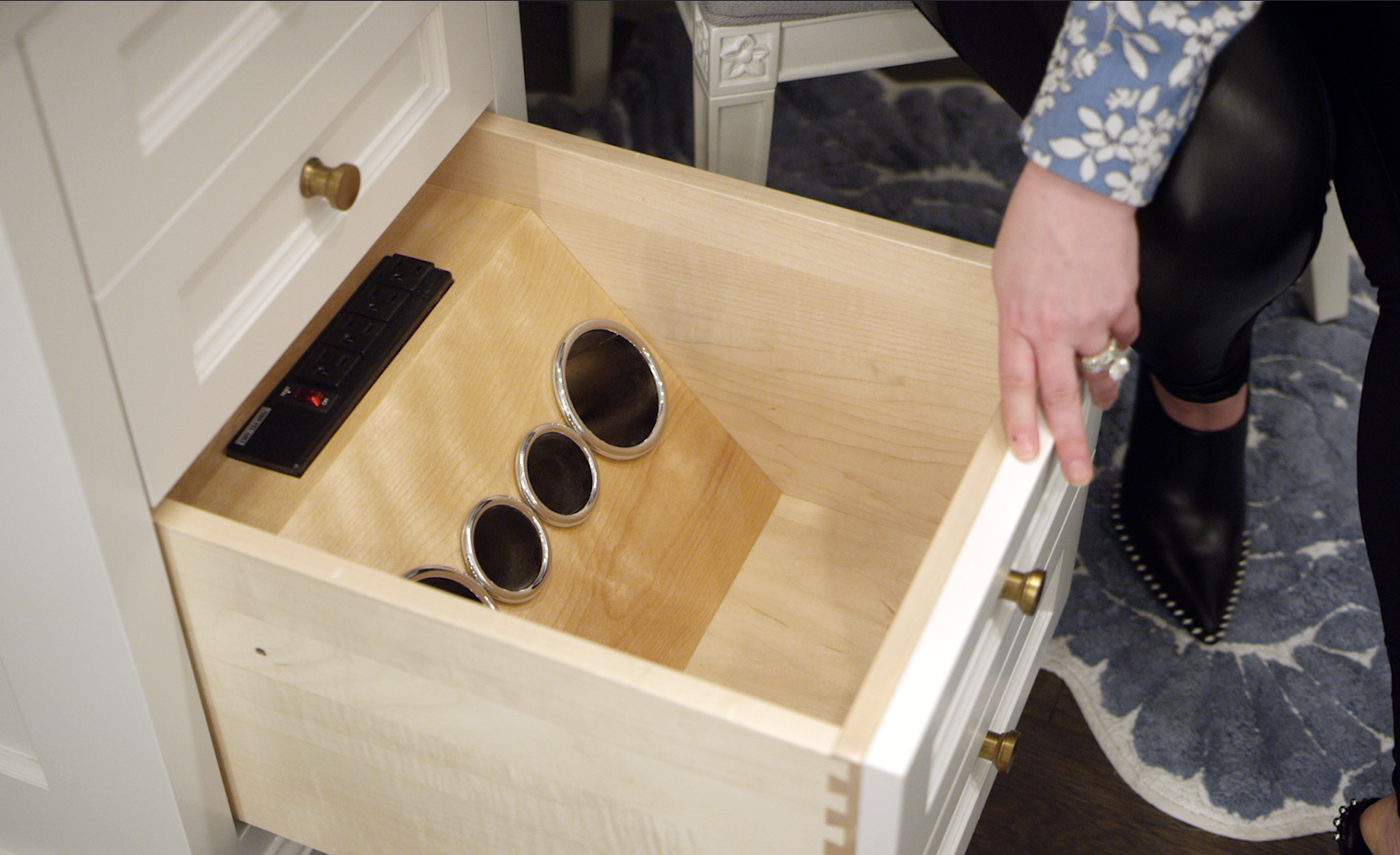 Carly Zucker shows the inside of a drawer with custom holder for hair styling tools.
