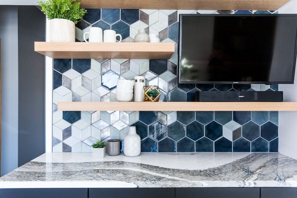 A kitchen and dining space bar with Cambria Skara Brae countertops and a backsplash created by Mercury Mosaics.