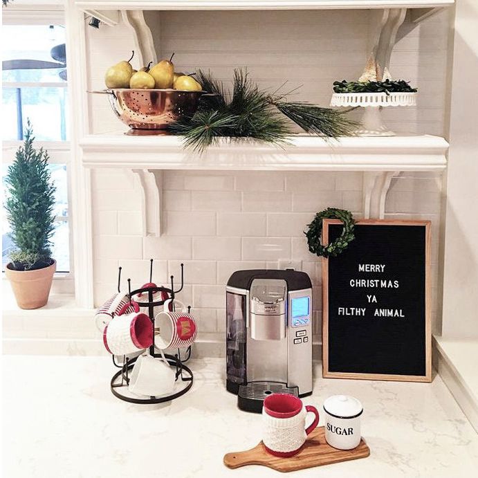 Cake stands and Christmas mugs create a cozy holiday moment.