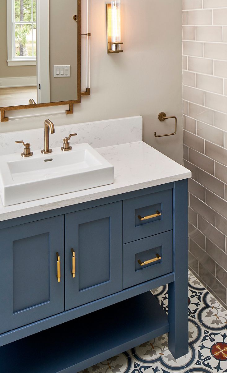 A blue vanity compliments Cambria Torquay and a mosaic tile.
