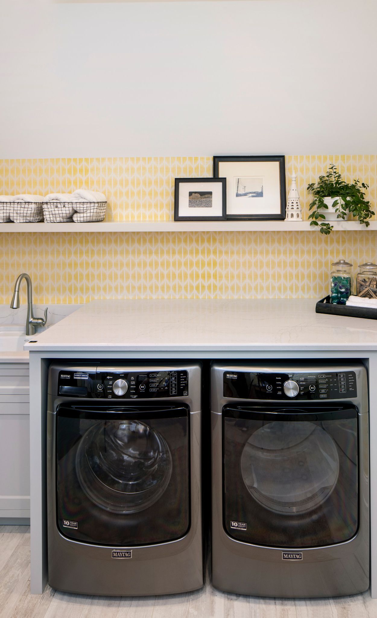 Cambria Ella in a laundry room with yellow wallpaper.
