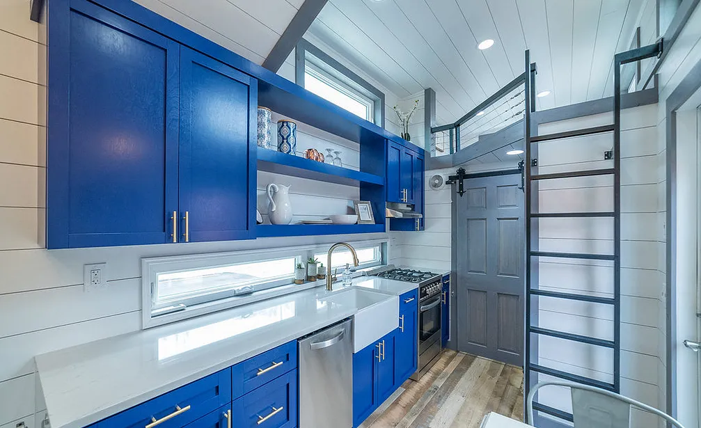 a tiny motor home kitchen with bright blue cabinets and white Ella quartz countertops