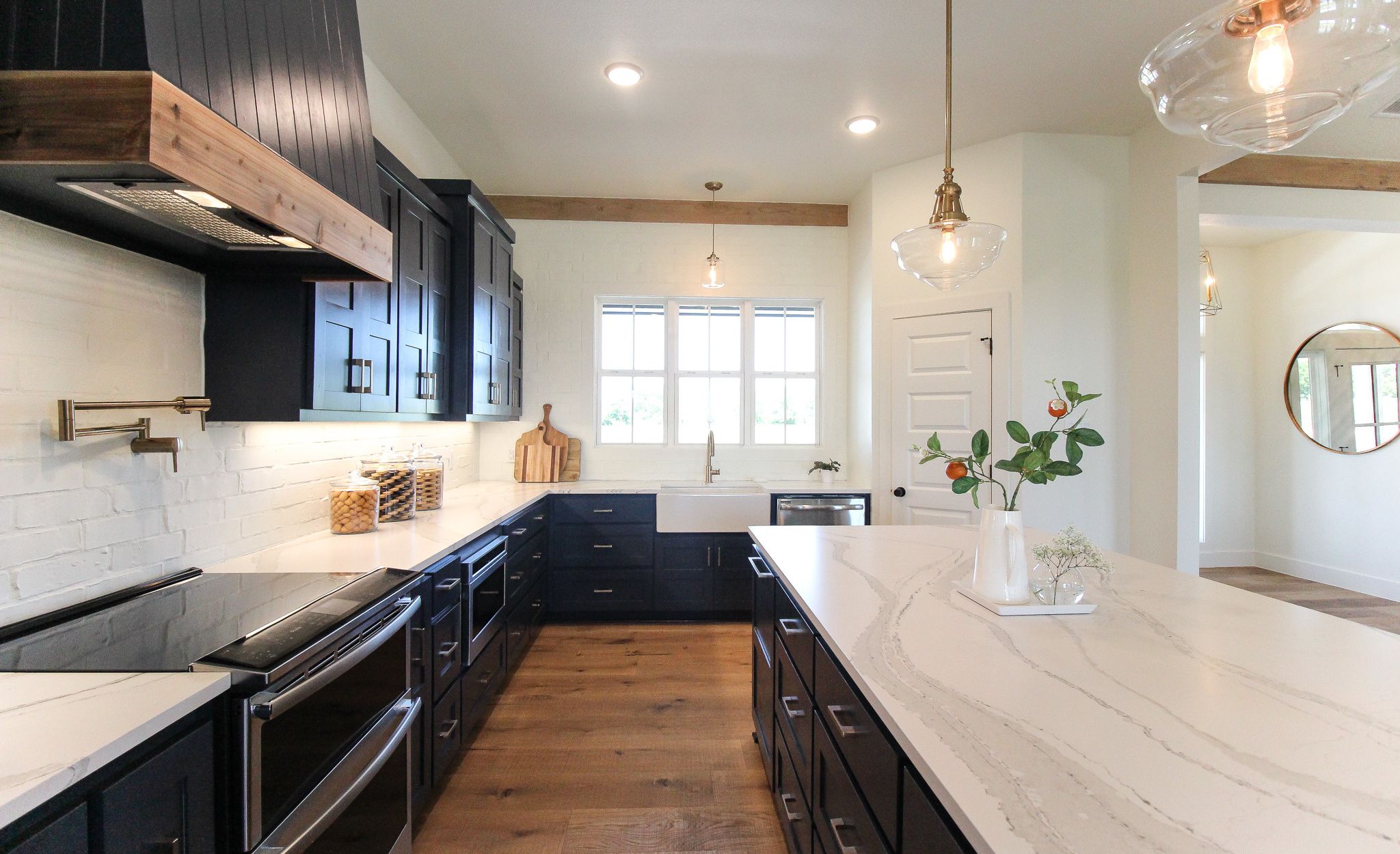 White marble-look quartz countertops paired with navy cabinets and white brick backsplash.