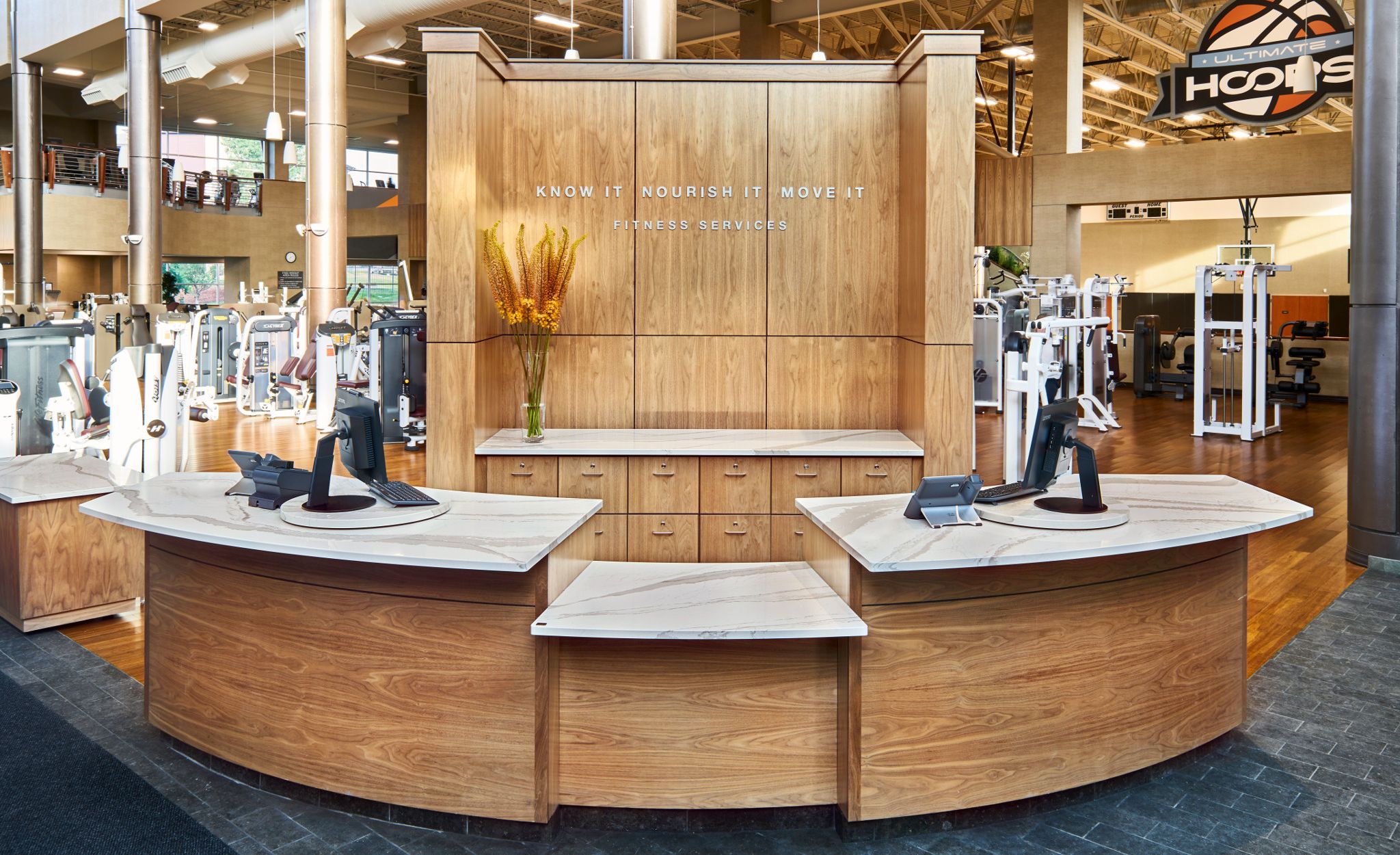 Reception desk featuring Cambria Brittanicca Warm countertops at Life Time fitness.