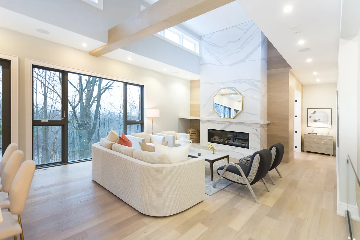 a bright open living room with large windows and a Brittanicca quartz fireplace surround