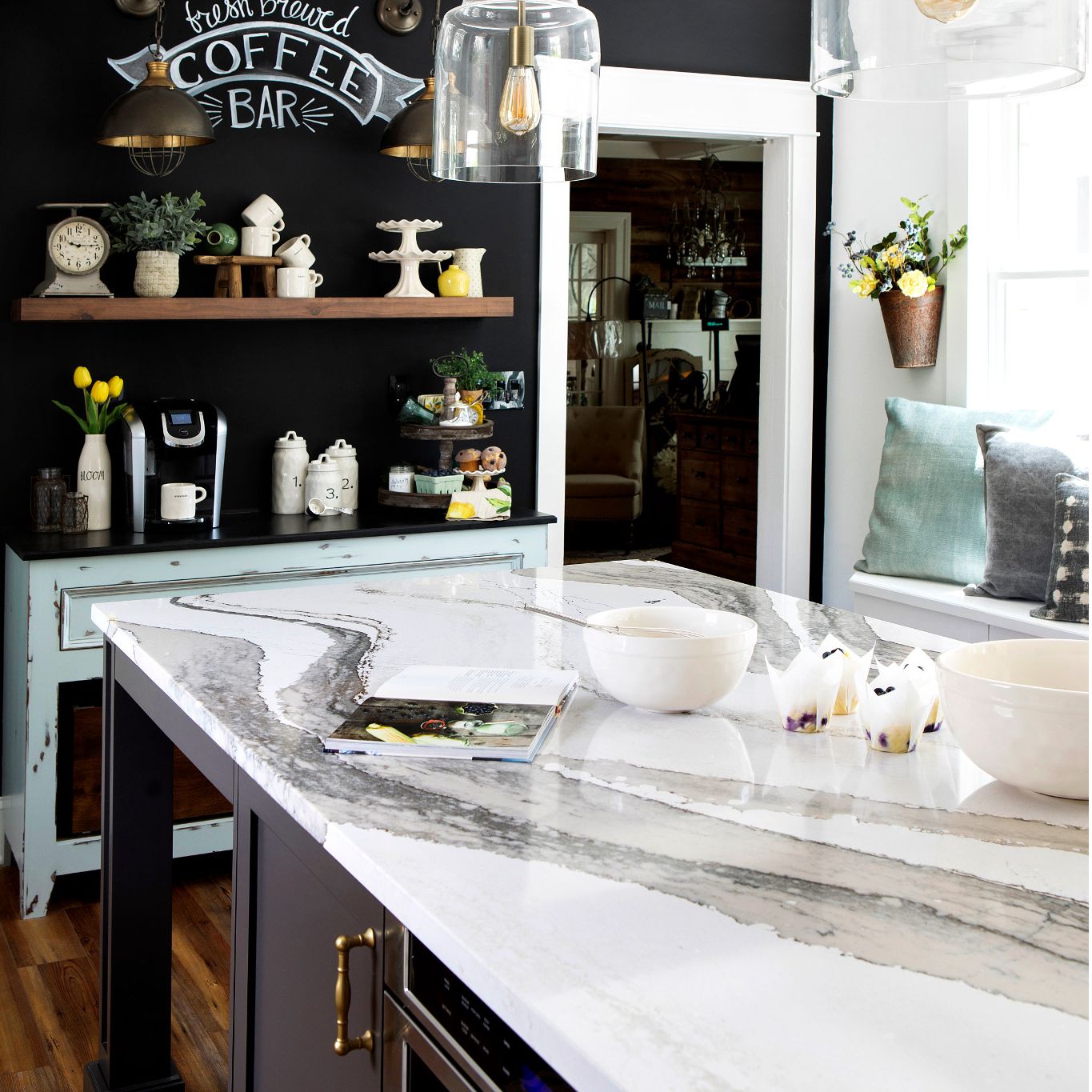 Warm toned kitchen with Skara Brae island countertops and a chalk wall.
