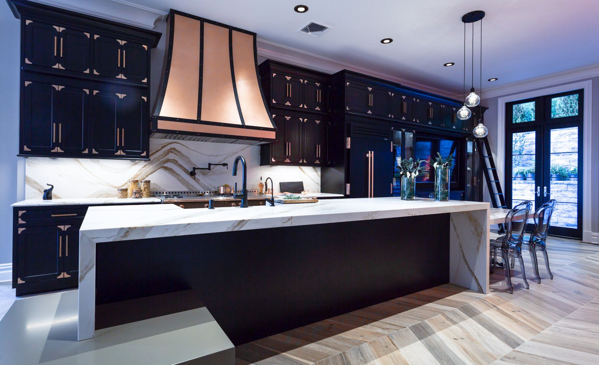 Gold marble-look quartz countertops in a black, high-contrast kitchen.