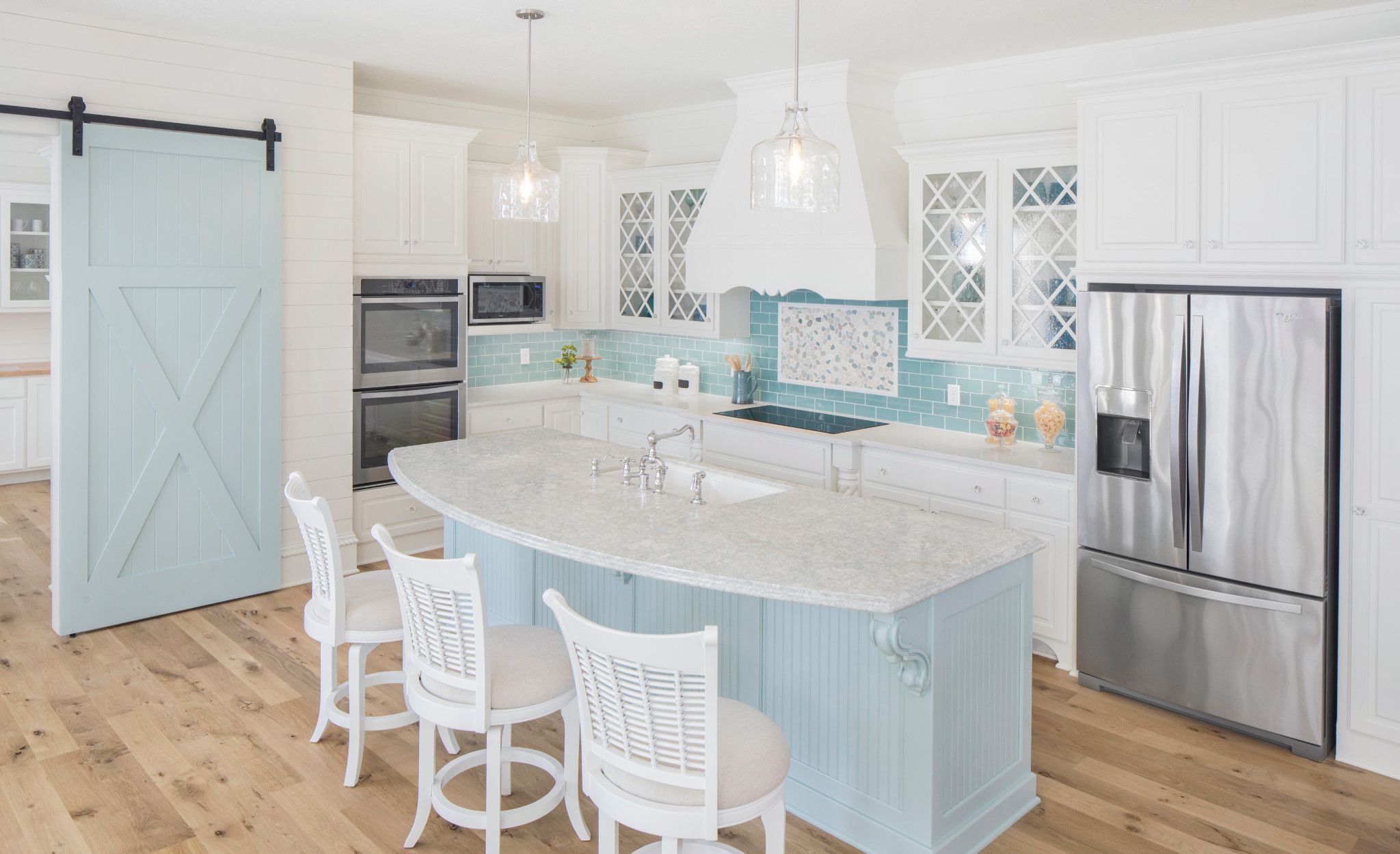 Coastal kitchen with pale blue island featuring Cambria Montgomery.