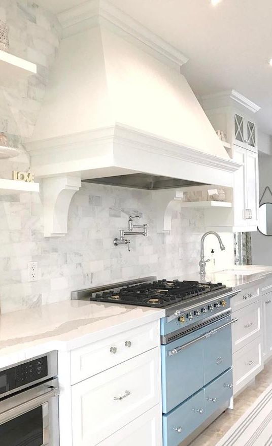 White kitchen with Cambria Brittanicca countertops and light blue range.