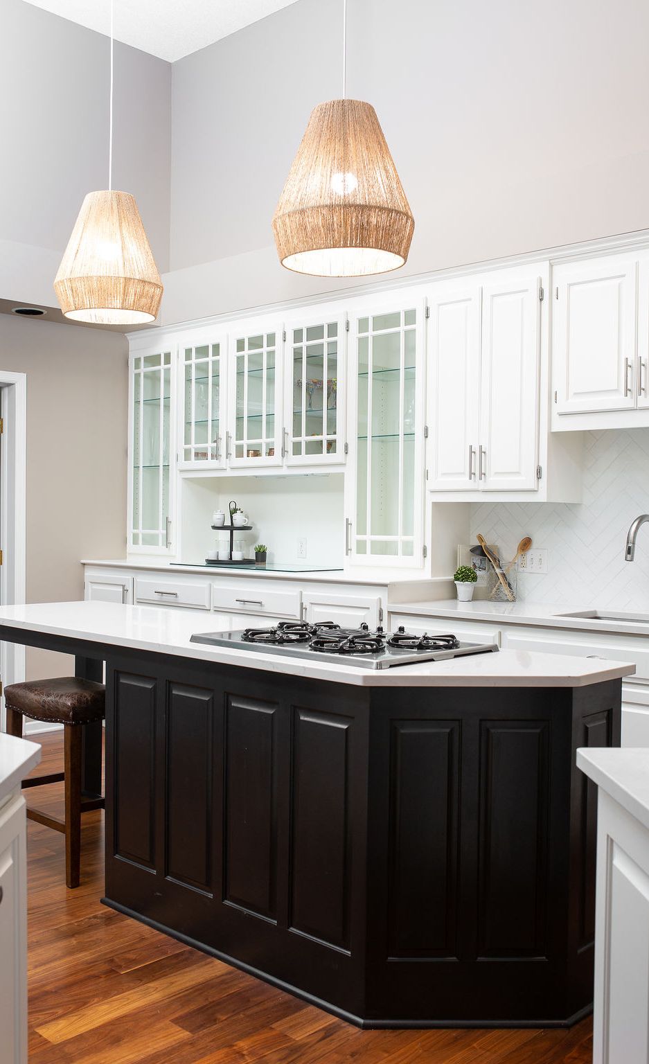 Pendant lights and dark cabinetry create a focal point for the Ella-topped kitchen island.
