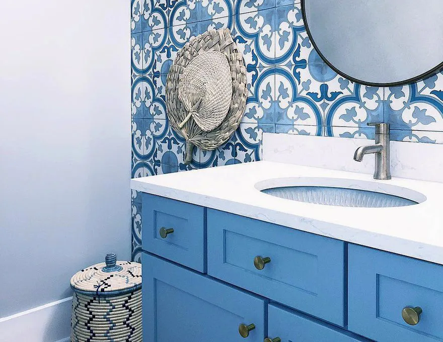 Bathroom with Blue Patterned Tile Walls, A Blue Vanity and A White Quartz Countertop