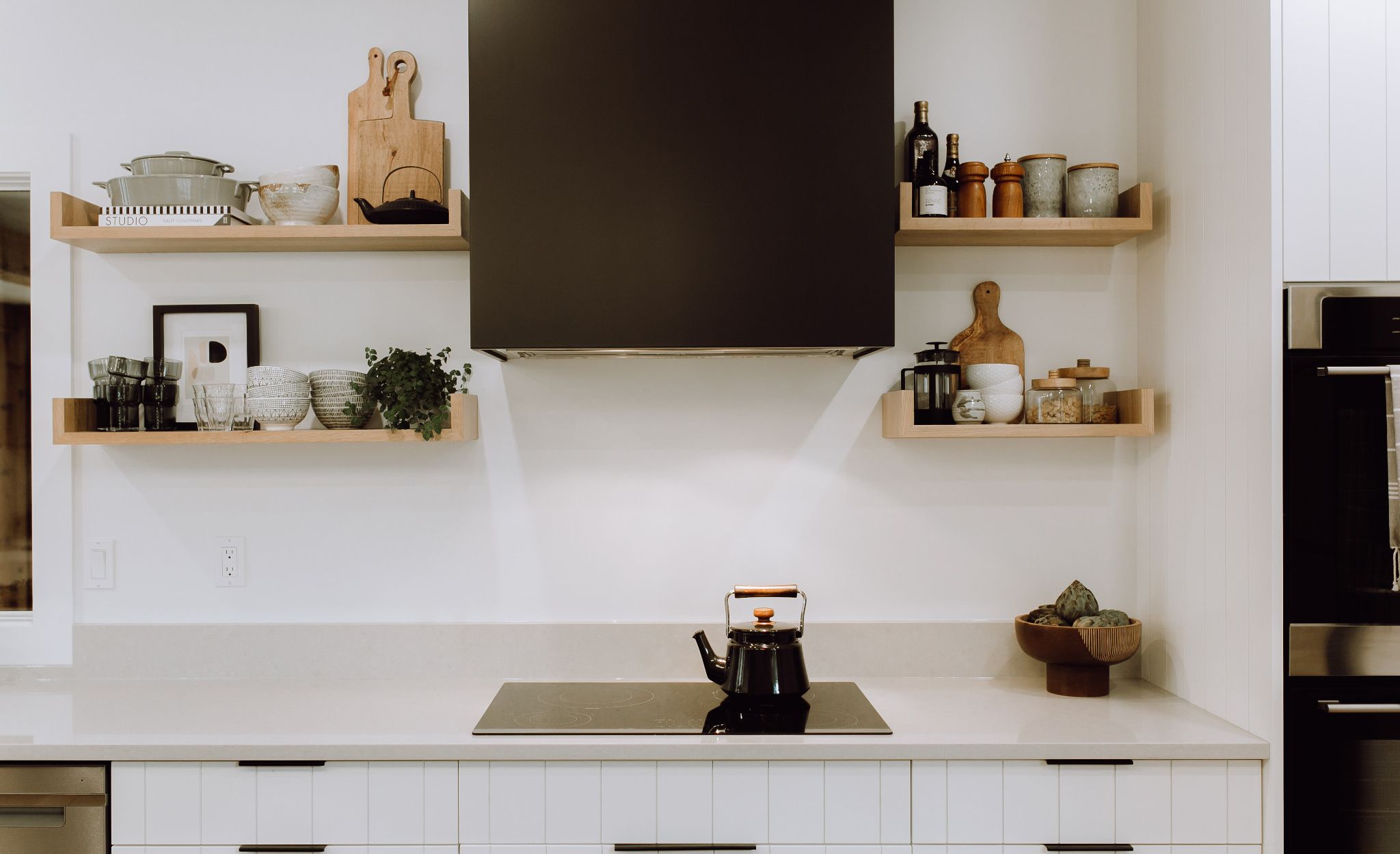 Cambria Templeton adds a light gray tone to this black and white kitchen.