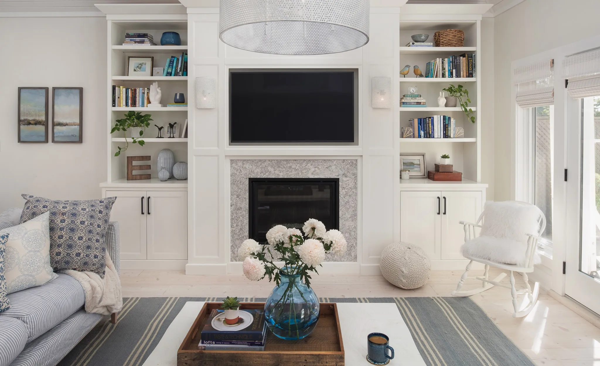 a blue and white living room with a white fireplace and a Berwyn quartz fireplace surround