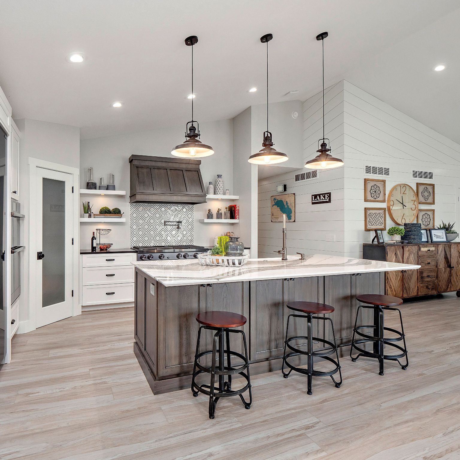 Weathered wood and white cabinets in a kitchen with Cambria Skara Brae on the island.