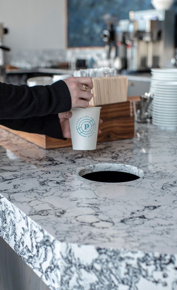 A precision-cut counter detail keeps waste bins hidden for a streamlined look on these Cambria Rosedale countertops.