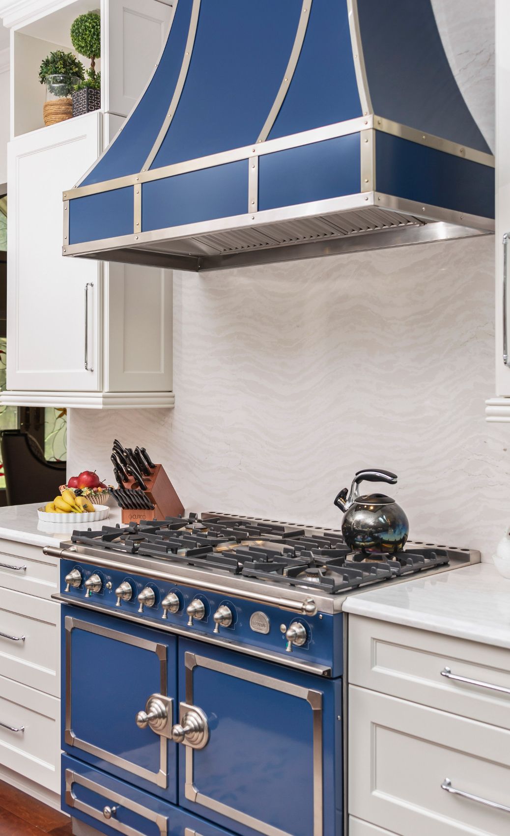 Cambria Delgatie™ creates a cascading tone-on-tone effect as a backsplash and countertops in this blue-and-white kitchen.