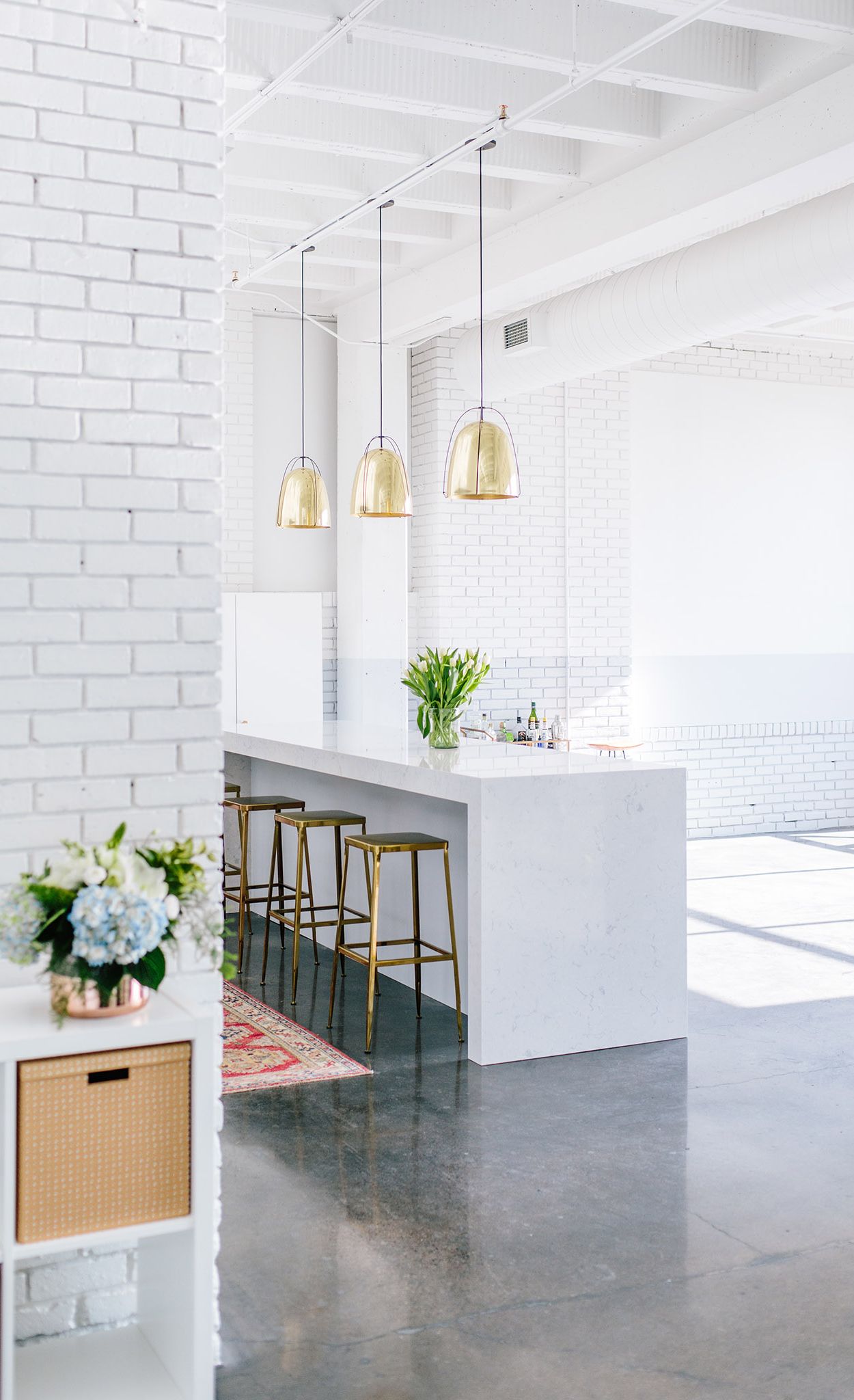 A kitchenette with Cambria Swanbridge island continues to serve as an inviting bar area, workspace, and gathering place.