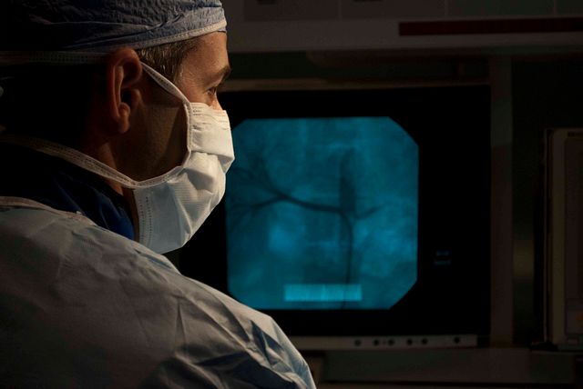 surgeon looking at an implanted medical device on a fluoroscope
