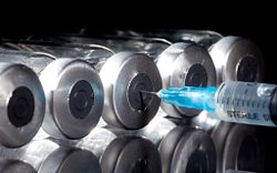 A vaccine candidate is injected by a syringe into a vial for vaccine development