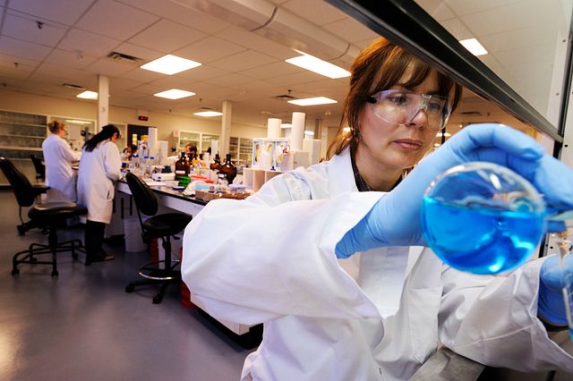 Formulation development scientist in fume hood using innovative approaches to develop optimal formulation for a pharmaceutical product