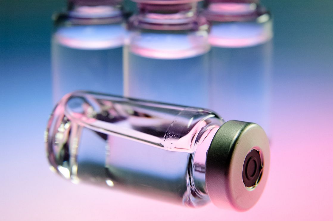 a pharmaceutical vial of clear liquid on its side