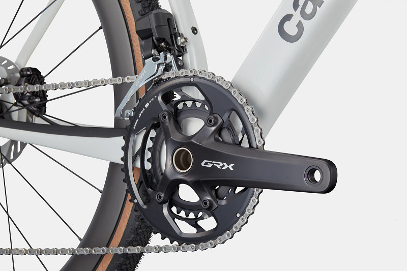 Close-up of a bicycle's crankset featuring a GRX component, chain, and part of the frame.