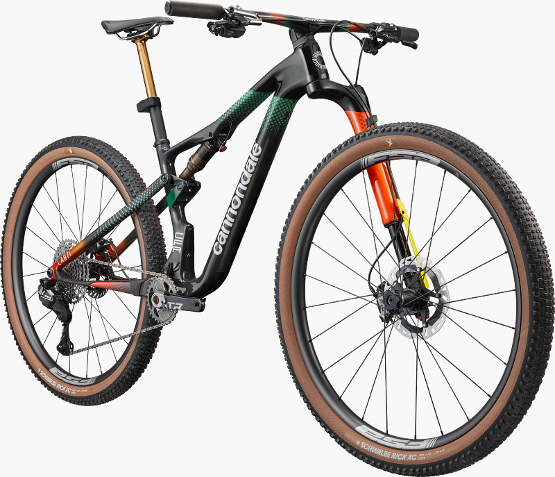 A modern mountain bike with a sleek black frame, colorful accents, and brown tires, showcasing advanced suspension and gear components.