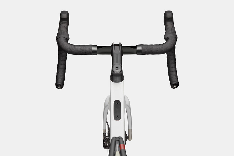 Top view of a bicycle handlebar with black grips and a sleek white frame.