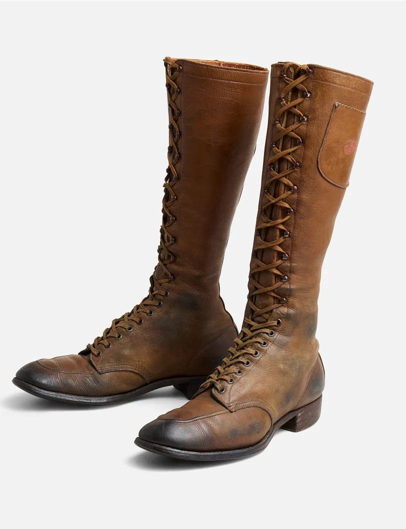 A pair of old worn Gloria boots against a white background