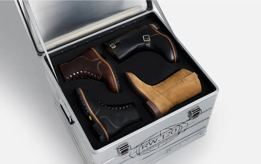 An open metal box against a white background that contains 4 different styles of Red Wing boots 