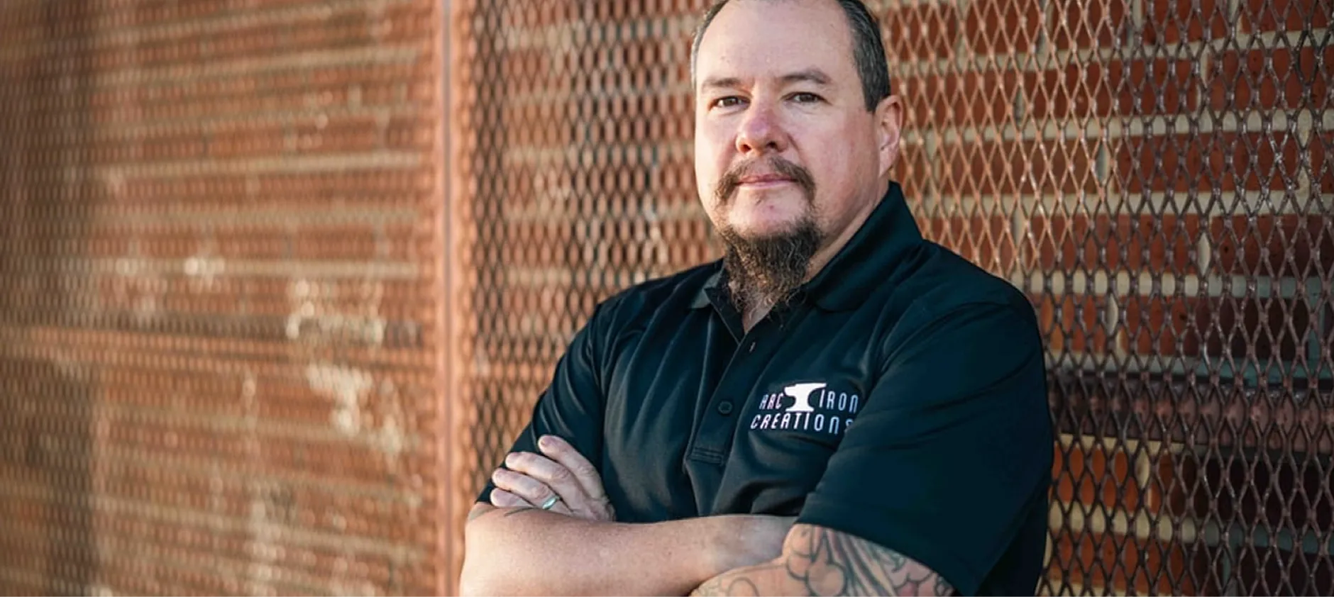 Closeup picture of Andrew R. Chambers Jr. with arms crossed leaning against a metal wall