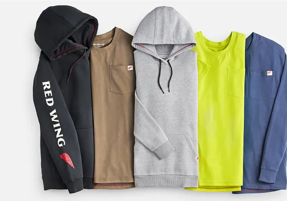 Overhead view of several shirts and sweatshirts against a white background