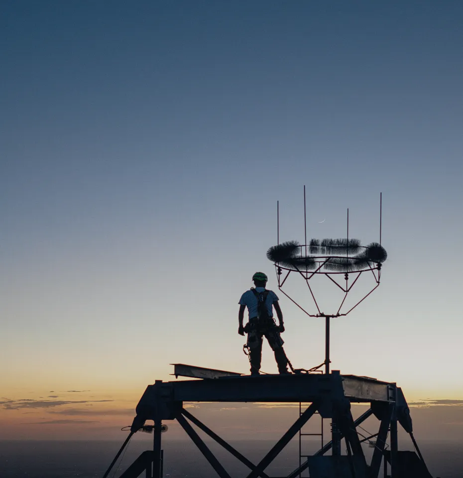 A main standing on a tall tower overlooking the horizon