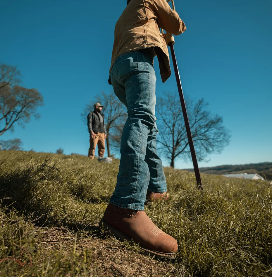 Two men standing on a grassy hill