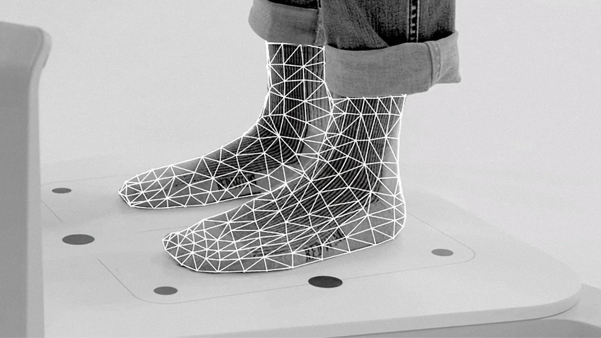 Closeup of a person's feet on the sizing machine with a grid matrix laid on top of the feet.