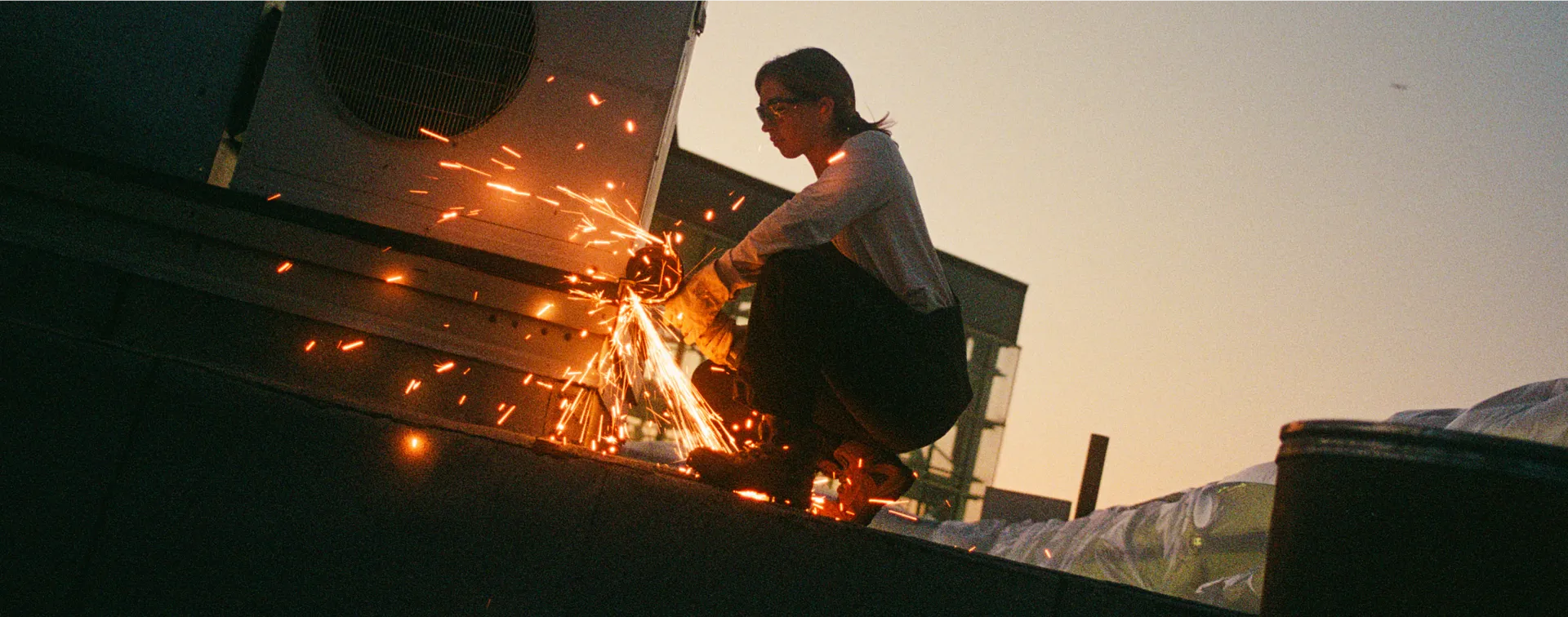 A woman using a grinder at a work site