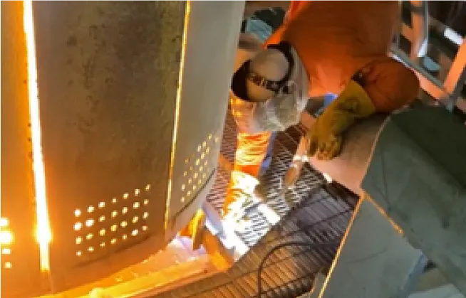 Nick Petito laying bricks on a jobsite by a hot furnace