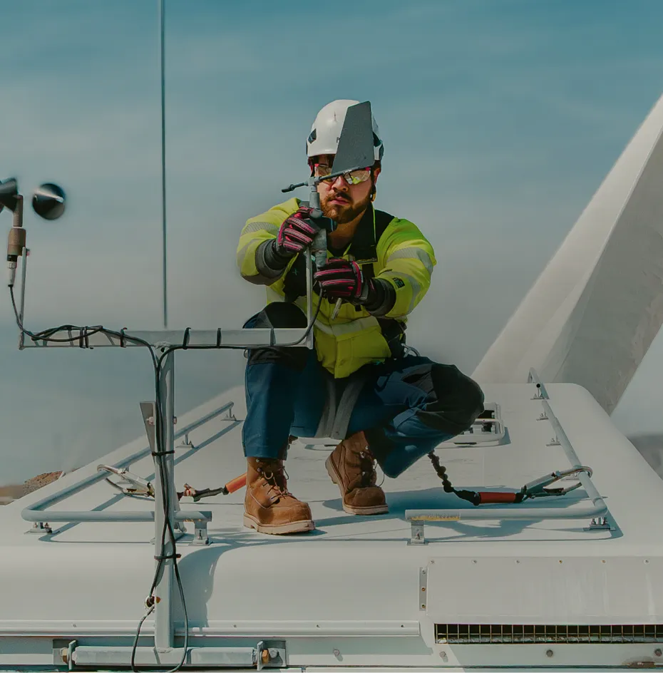 A man in workwear at a jobsite kneeling on a platform