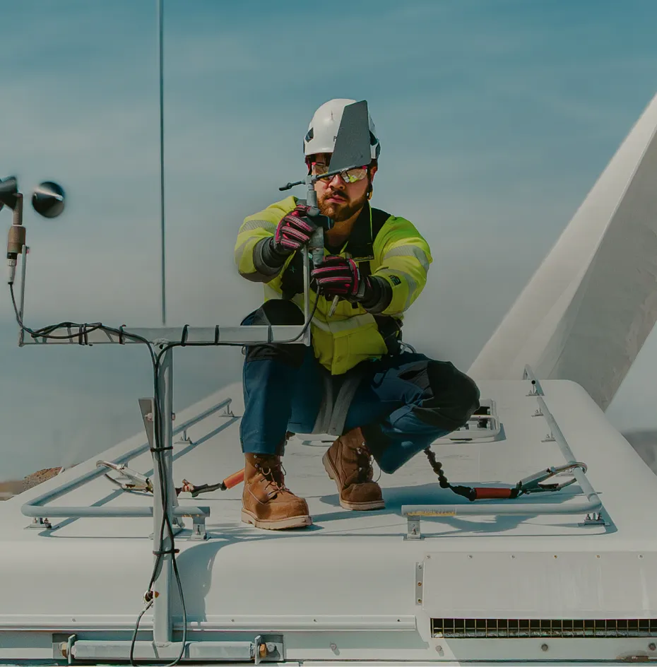 A man in workwear at a jobsite kneeling on a platform